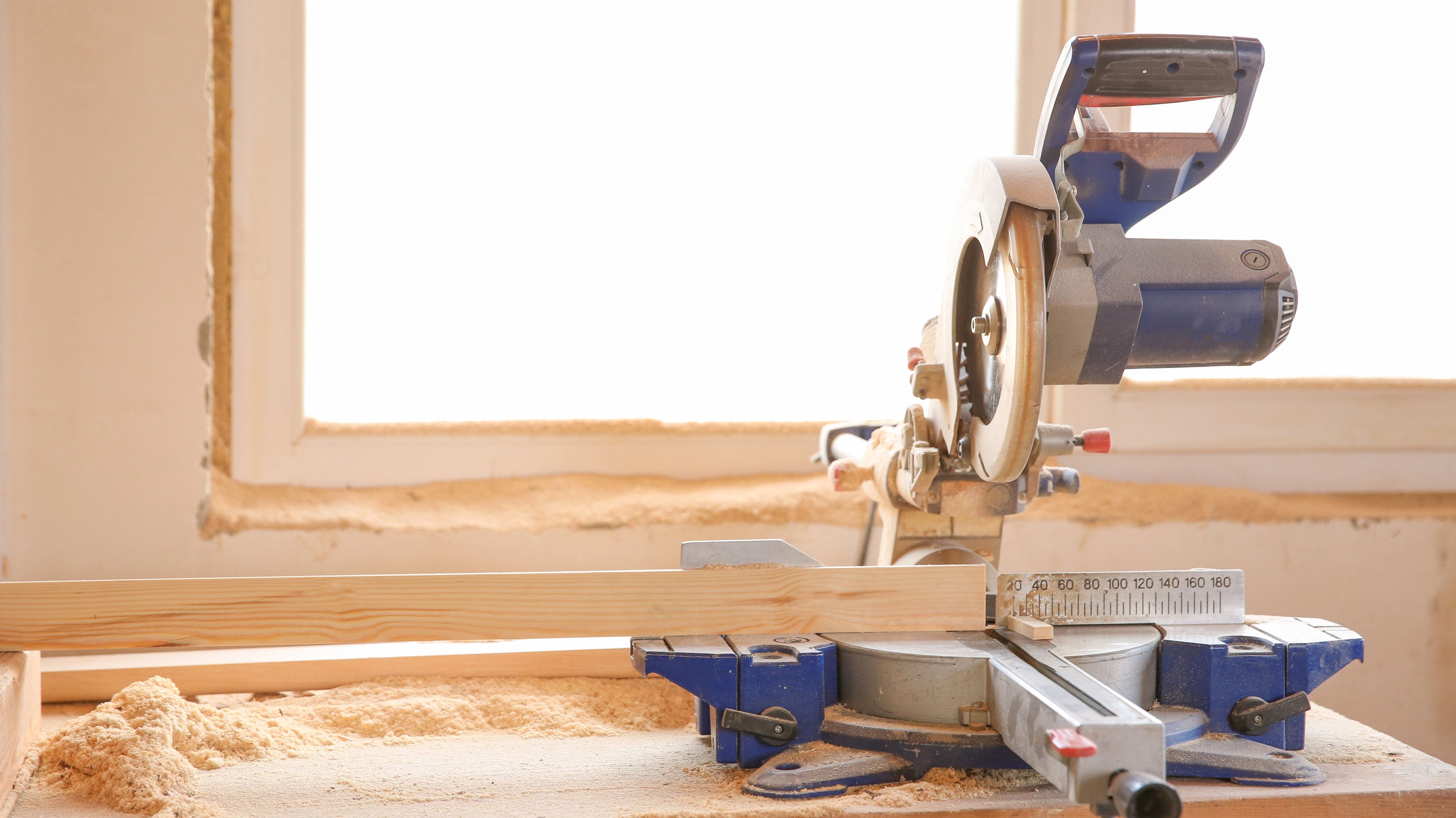 Sierra de mesa industrial cortando pieza de madera en taller profesional